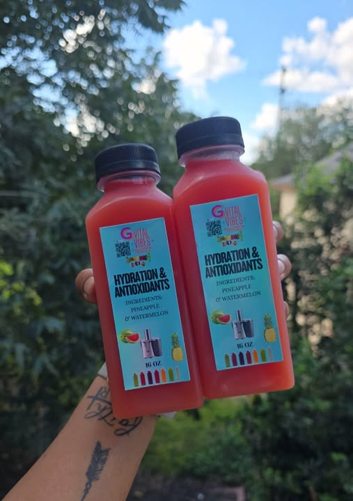 Fresh G-Vital Vibes juice bottles held outdoors